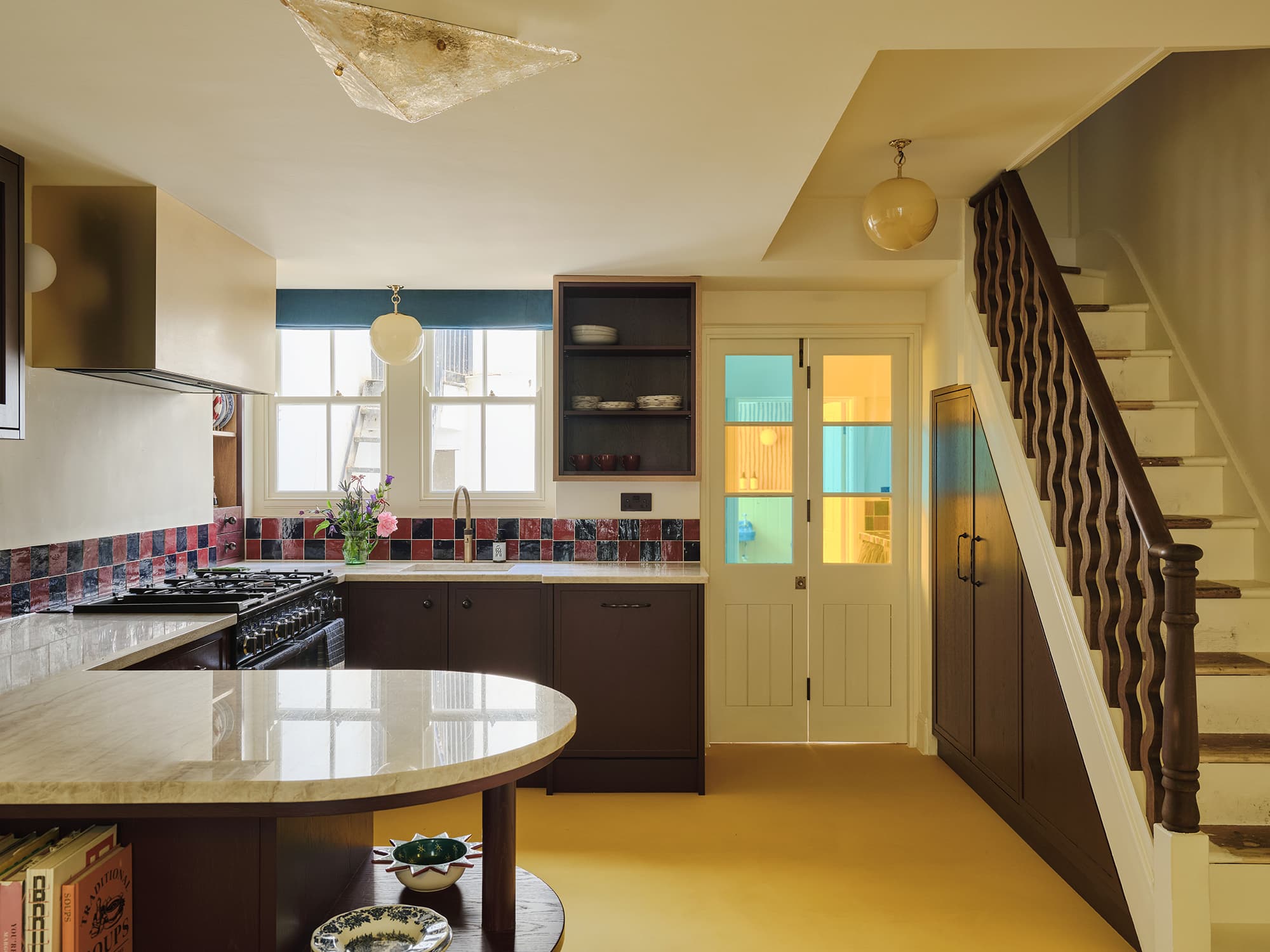 Modern kitchen with island, cabinets, and staircase
